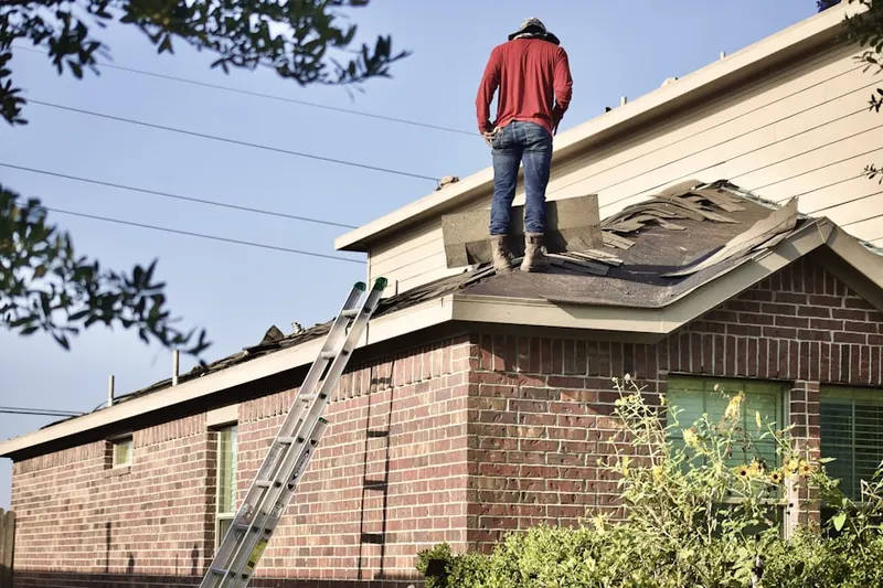 Professional roofer working on a residential roof in Riverton Heights